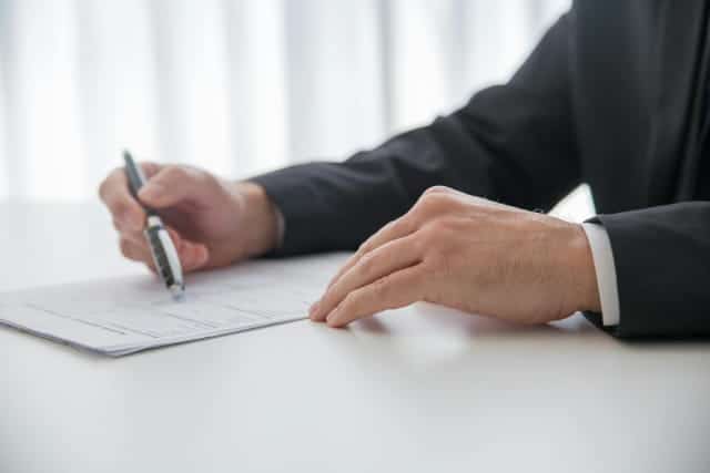 Professional signing insurance paperwork for landlord risk and coverage review